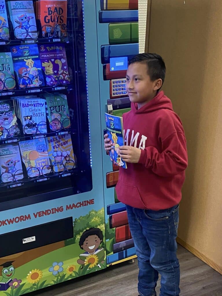 Boy holding book that he received from book vending machine
